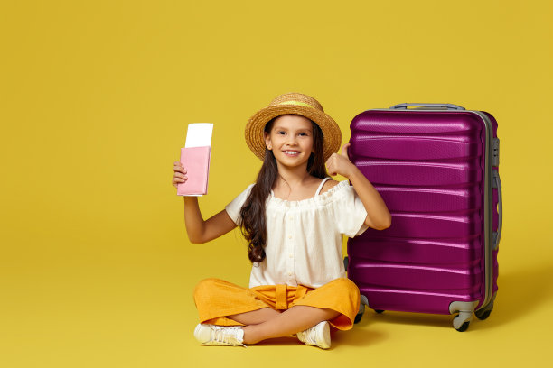 小女孩拿着旅行箱和护照坐在地板上图片下载