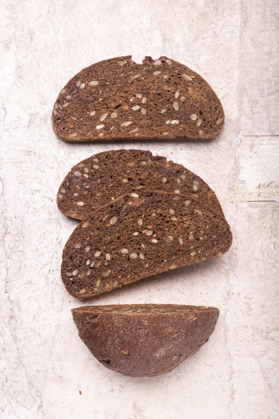 黑麦面粉面包，种子和坚果在旧纸上。健康食品的概念。图片下载