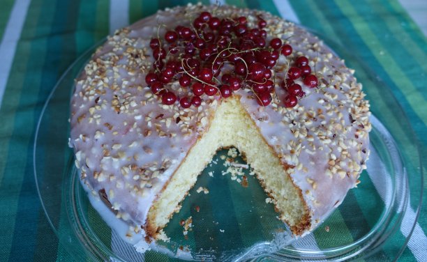 一个切好的蛋糕，上面有糖釉，切碎的榛子和红醋栗图片下载