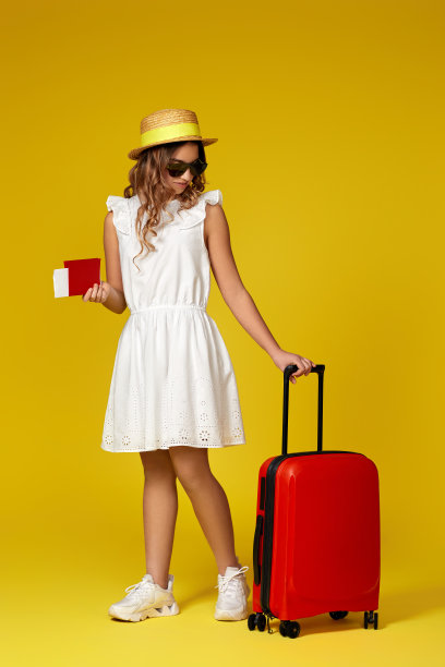 戴帽子和太阳镜、手提红色手提箱的少女图片下载