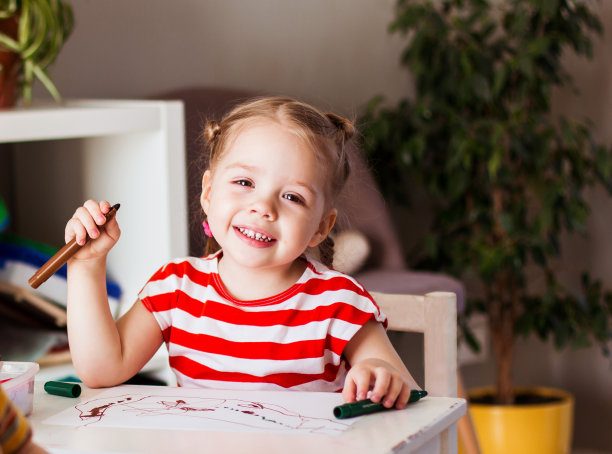 小女孩和男孩坐在家里的桌子旁图片下载