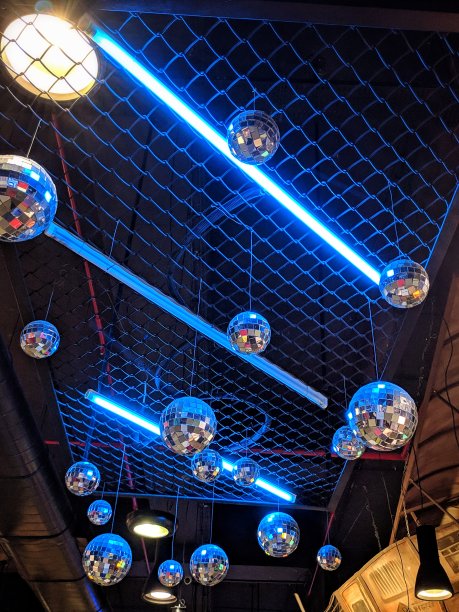 全套室内家具公寓在现代公寓与天井，餐厅在现代风格与纹理的墙壁和拼花。有灰色的沙发与桌子，装饰物品，天花板上有圆形的轻球几何结构图片下载