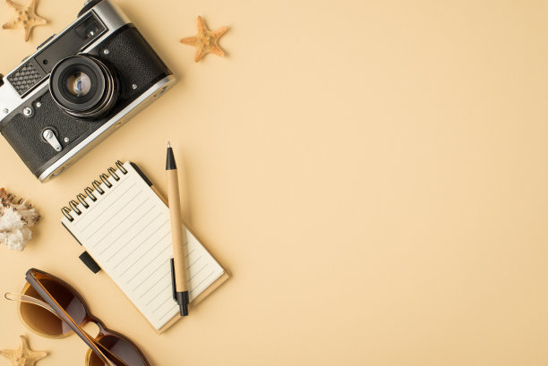 俯视图照片的相机规划笔太阳镜海贝和海星在孤立的米色背景与空白图片下载