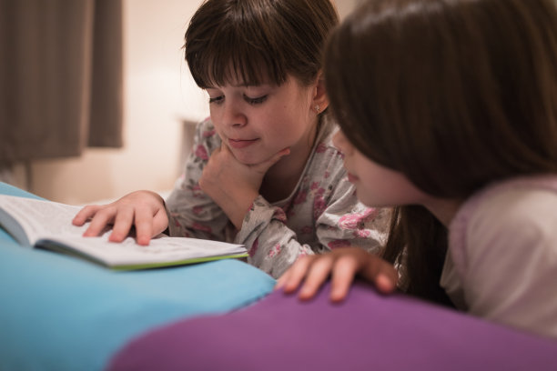 兄弟姐妹躺在床上看书图片下载