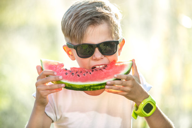 戴眼镜吃多汁西瓜的搞笑小孩图片下载