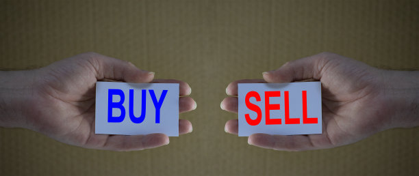 手里拿着卡片，上面写着“买”和“卖”。金融分析，股票市场，经济的概念图片下载