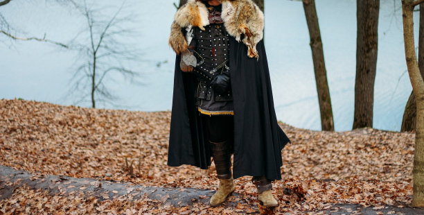 森林中身着盔甲手持利剑的中世纪骑士。一个穿着盔甲，披着狼斗篷的男人图片下载