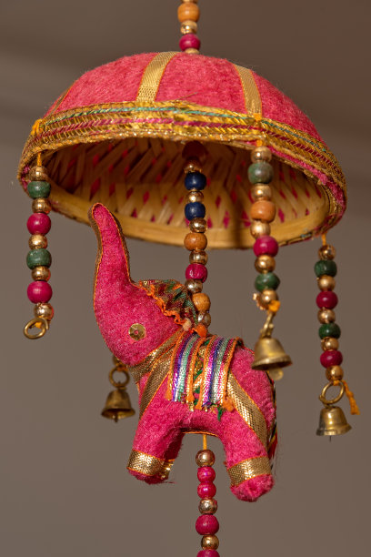 作为装饰品的大象玩具。用铃铛装饰的阳伞下的织物大象图片下载