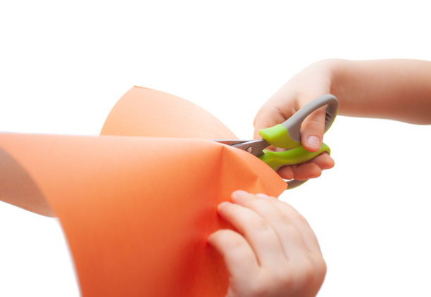 孩子们的手在白色的背景上剪彩色的纸图片下载