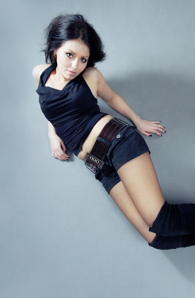 照片中，这位年轻的模特穿着吊带衫和短裤躺在地板上图片下载