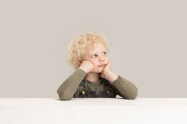 一个白人小男孩在灰色的工作室背景下摆出孤立的姿势。图片下载