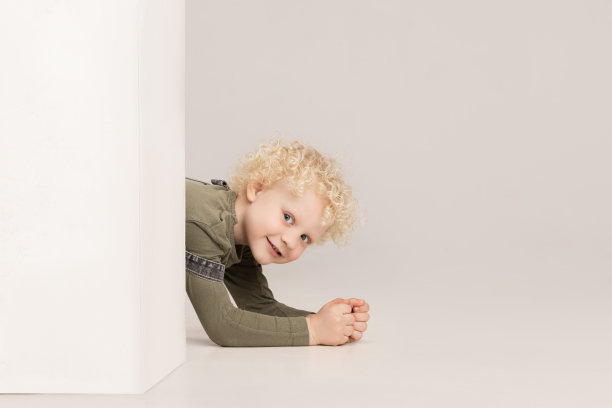 一个学龄前小男孩的肖像在灰色的工作室背景上摆出孤立的姿势。图片下载