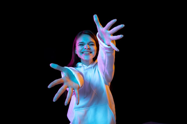 特写年轻美丽的女孩手势孤立在黑暗的背景。图片下载