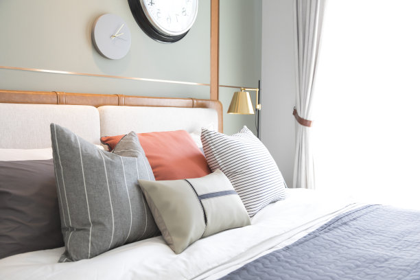 白色和柔和的橙色设计枕头在舒适的卧室。图片下载