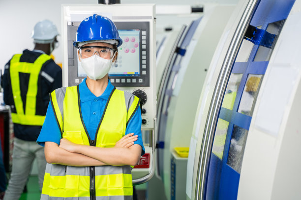 新冠肺炎疫情爆发后，亚洲女工戴着防护口罩的照片。女工程师在工业中操作机器的保健工作。图片下载