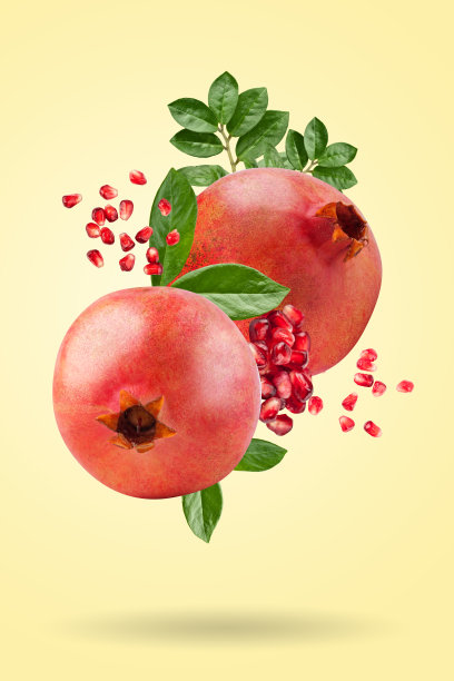 成熟的石榴漂浮在黄色的背景上。背景以石榴果。水平的。图片下载