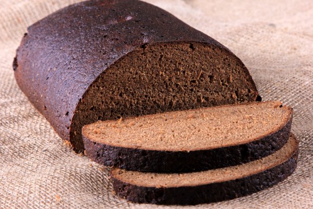 新鲜的黑麦切片面包条孤立在木桌和餐巾上图片下载