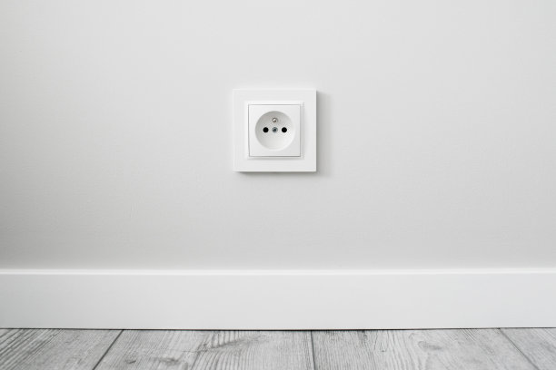新的电源插座隔离在灰色的墙上。装修工作室公寓电源背景。图片下载