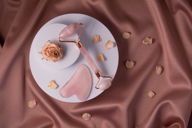 玉滚子，瓜沙和干玫瑰和花瓣放在白色的讲台上。图片下载