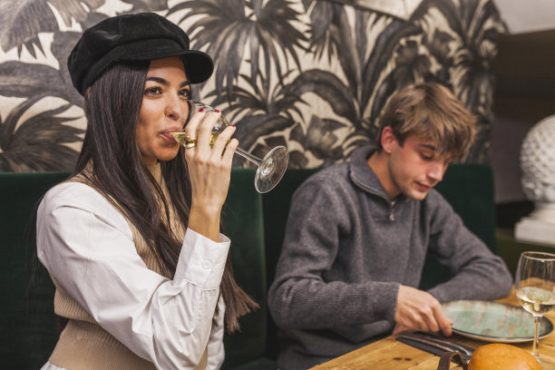 优雅的女子喝了一杯白葡萄酒图片下载