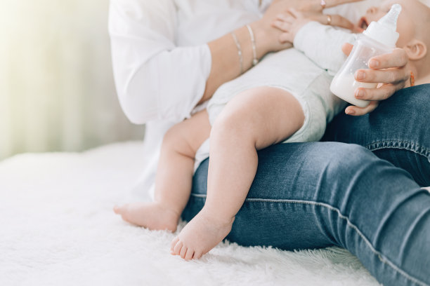 慈爱的母亲用奶瓶喂养她刚出生的婴儿。照顾儿童的健康。儿童人工喂养图片下载