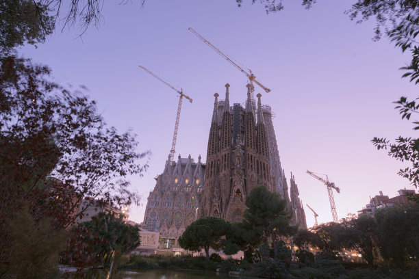 圣家堂圣诞节的正面，从公园可以看到教堂。建筑起重机正在建造西班牙巴塞罗那大厦图片下载