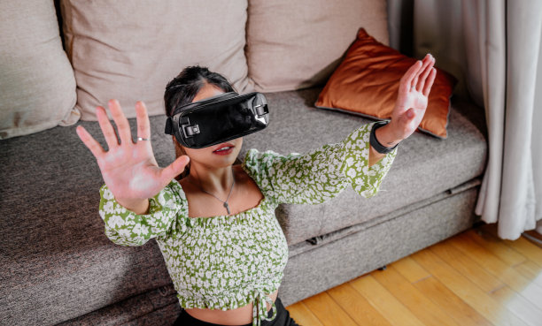 亚洲女性在家里通过虚拟现实设备查看。增强现实，游戏，未来技术概念。虚拟现实图片下载