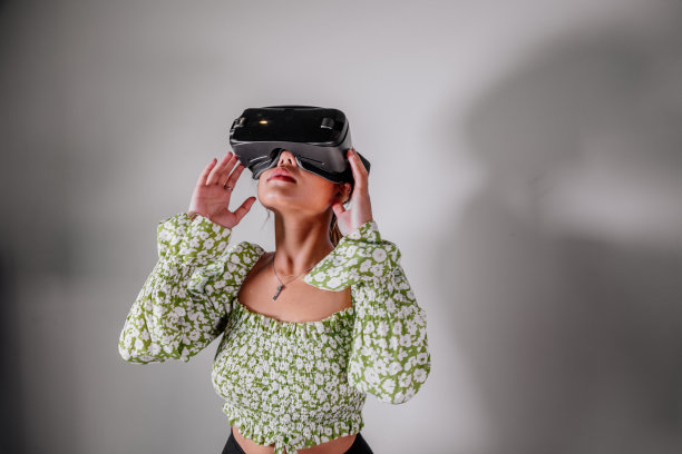 亚洲女性在家里通过虚拟现实设备查看。增强现实，游戏，未来技术概念。虚拟现实图片下载