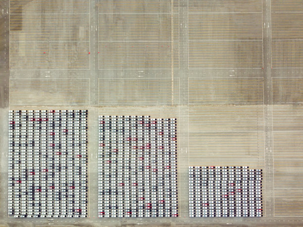 无人机俯瞰停车场等待出口给客户的新车。图片下载