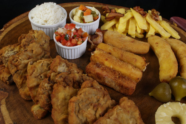 美味的古巴鱼片。由面包屑牛排，香蕉，面包屑奶酪和火腿，薯条与培根，醋油沙司，精选蔬菜，白米饭，桃菠萝和无花果。俯视图特写照片。图片下载