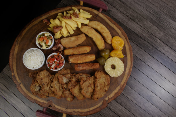 古巴鱼片。由面包屑牛排，奶酪，面包屑火腿和香蕉，醋油沙司，白米，菠萝和无花果制成。俯视图照片，有文字空间。图片下载