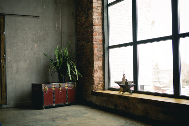 整个混凝土墙面上有一个巨大的窗户，上面有一个木制的窗台。阁楼工业垃圾室内。砖和黑暗的背景。图片下载