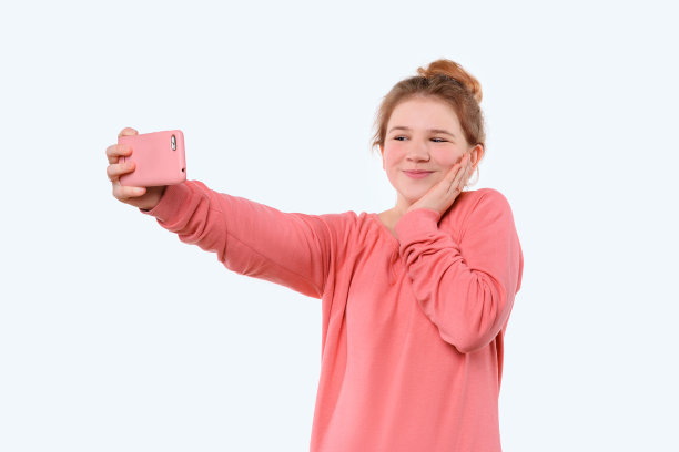 一个年轻的女孩正在用电话进行视频通话，在线会议。她和她的朋友聊天图片下载