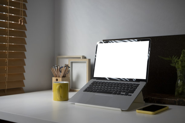 模拟笔记本电脑空白屏幕，咖啡杯和手机在白色的桌子上。图片下载