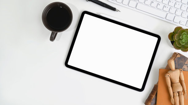 白色办公桌，数字平板电脑，咖啡杯，键盘和仙人掌。图片下载