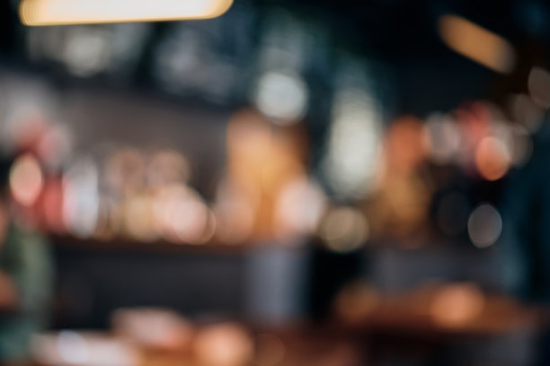 咖啡店用散景灯光模糊背景。酒吧和桌子模糊的轮廓，昏暗的灯光图片下载
