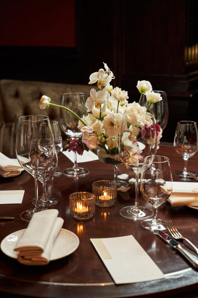 一张桌子，中间放着一束白色的花束，还有燃烧的蜡烛图片下载