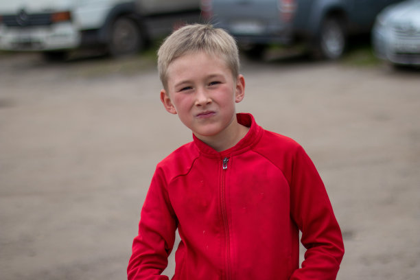 一个穿着鲜艳夹克的男孩的肖像。调用。他看着摄像机。的情绪。把手放在口袋里。图片下载