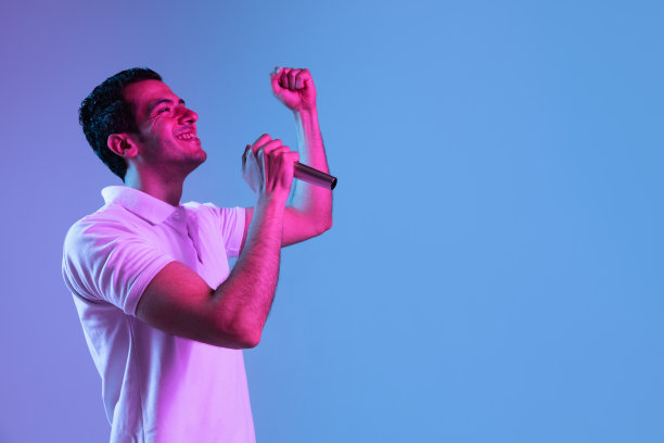 拉丁裔年轻人的肖像在紫色蓝色的工作室背景霓虹灯。人的情感、面部表情、青春、销售、广告的概念。图片下载