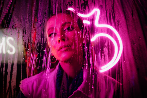 在下雨的街道上，一个女人透过潮湿的窗户望出去图片下载