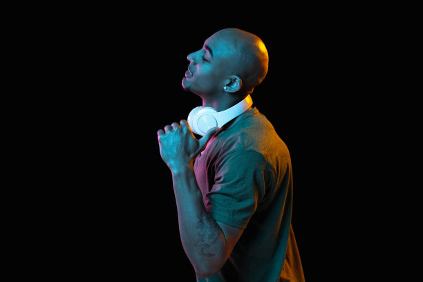 一个非洲裔美国年轻人的肖像，背景是霓虹灯。人的情感、面部表情、青春、销售、广告的概念。图片下载