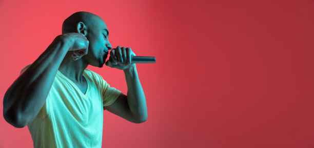 一个非洲裔美国年轻人的肖像，在红色的霓虹灯背景下。人的情感、面部表情、青春、销售、广告的概念。图片下载