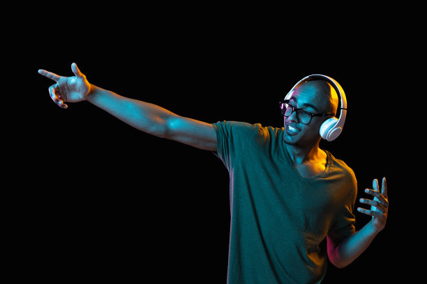 一个非洲裔美国年轻人的肖像，背景是霓虹灯。人的情感、面部表情、青春、销售、广告的概念。图片下载