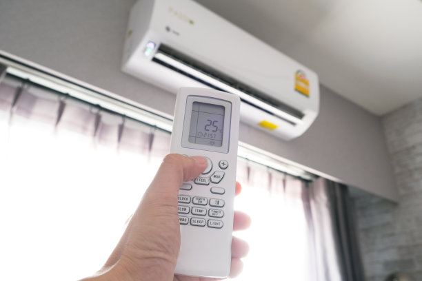 男人的手用遥控器打开他卧室里的空调被冷却到25摄氏度。健康理念和节能图片下载