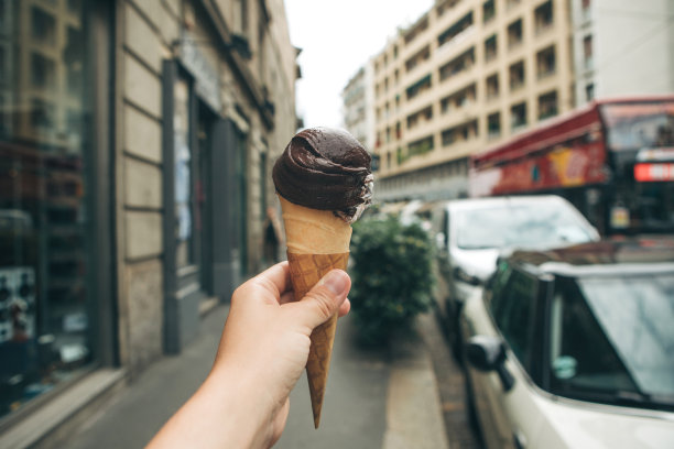 女孩拿着华夫筒里的巧克力冰淇淋图片下载