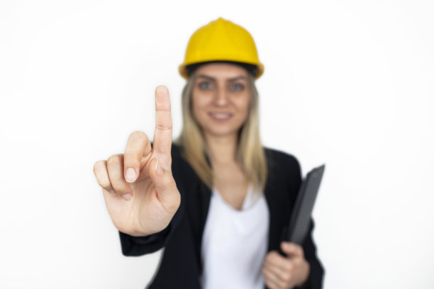 年轻的工程师的女人。年轻的女商人用手指着。图片下载