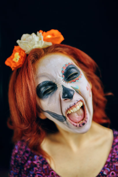 年轻女子在死去的日子里戴着骷髅脸的面具。图片下载