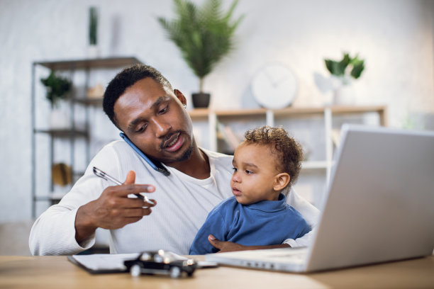 一个跪着的儿子在家用笔记本电脑工作的男人图片下载