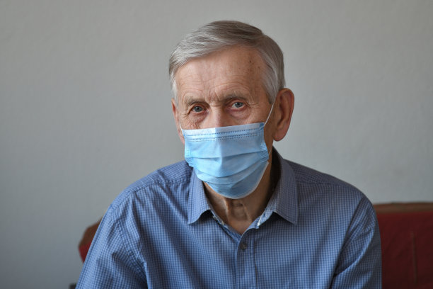 一个悲伤的老人的肖像，80岁，戴着医用口罩。图片下载