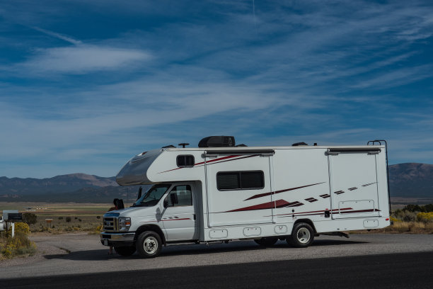 c型露营车与滑站在沙漠与山的背景图片下载